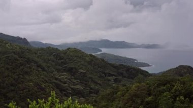 Yeşil dağ bulutlu yağışlı hava, panorama, dağın zirvesine adada beyaz bulutlar altında gizlidir.