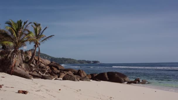 Hermosa playa con arena blanca y grandes piedras bañadas por el océano . — Vídeos de Stock