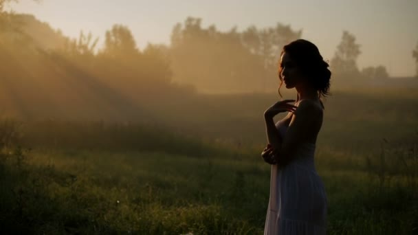 Belle fille en robe blanche posant sur la caméra . Séquence Vidéo