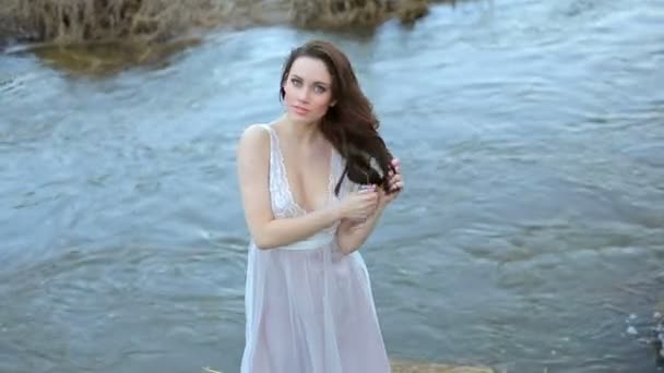 Vacker flicka i vit klänning poserar på kameran. — Stockvideo