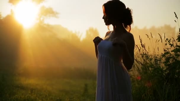 Belle fille en robe blanche posant sur la caméra . Séquence Vidéo