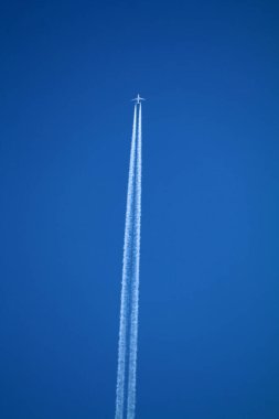 Kimyasal izlerle gökyüzünde uçan bir uçak. 