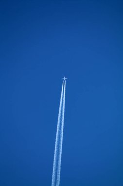 Kimyasal izlerle gökyüzünde uçan bir uçak. 