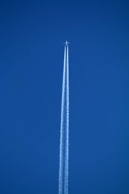 Kimyasal izlerle gökyüzünde uçan bir uçak. 