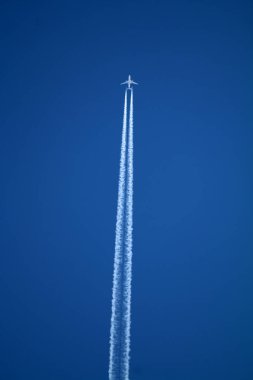 Kimyasal izlerle gökyüzünde uçan bir uçak. 