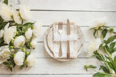 Sofra ve gümüş bir buket beyaz peonies eski Beyaz ahşap kurullarında, üstten görünüm