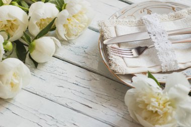 Sofra ve Gümüş eşyalar eski Beyaz ahşap kurullarında, yumuşak odak arka plan beyaz peonies bir buket
