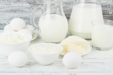 Beyaz ahşap zemin üzerinde farklı süt ürünleri