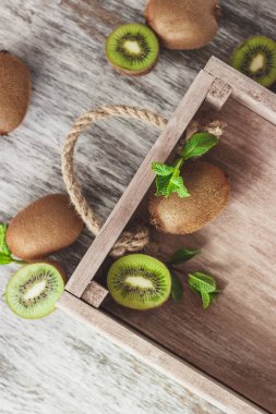 Yeşil kivi ve nane yaprakları ahşap tepsi, üstten görünüm