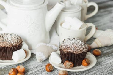 Su bardağı kakao ve şekerleme, kek ve farklı süslemeler, yumuşak odak arka plan ile