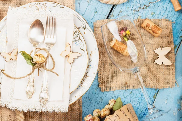 Sofra ve kuru çiçekler ve mavi eski ahşap arka plan üzerinde farklı süslemeler ile Gümüş eşyalar