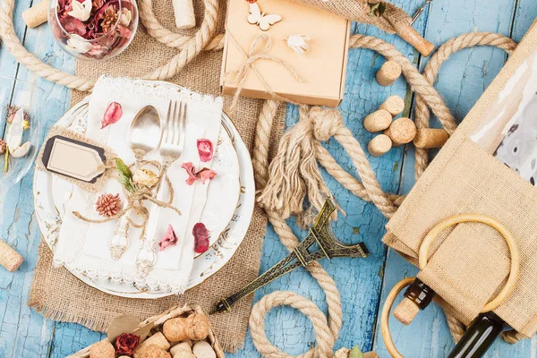 Sofra ve kuru çiçekler ve mavi eski ahşap arka plan üzerinde farklı süslemeler ile Gümüş eşyalar