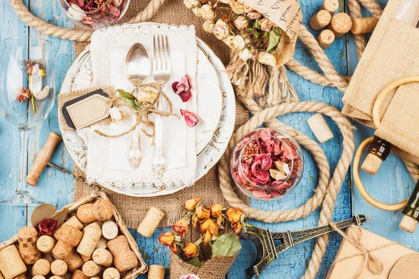 Sofra ve kuru çiçekler ve mavi eski ahşap arka plan üzerinde farklı süslemeler ile Gümüş eşyalar