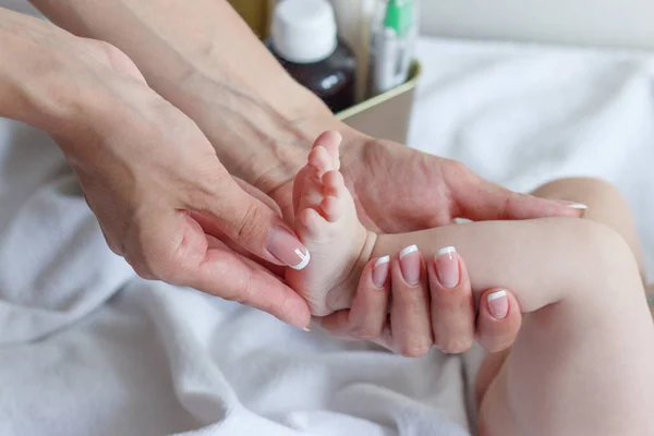 Mani Della Donna Tiene Piede Del Bambino Sfondo Soft Focus — Foto Stock