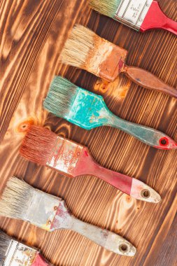 Farklı renkli fırçalar ahşap arka plan üzerinde çapraz çizgi 