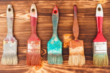 Satırından farklı renkli ahşap arka plan üzerinde fırçalar 