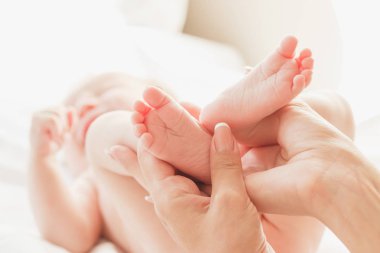 Annenin elleri ve bebeği, içeride, yumuşak odaklı arka plan.