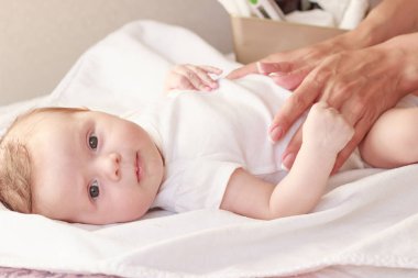 Annenin elleri ve bebeği, içeride, yumuşak odaklı arka plan.