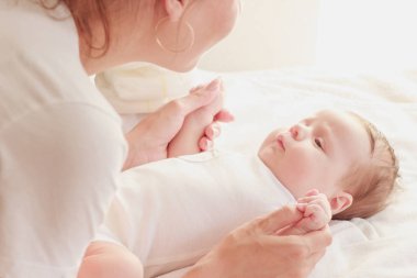 Annenin elleri ve bebeği, içeride, yumuşak odaklı arka plan.