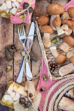 Vejetaryen kümesi: çiğ beyaz mantar, çam kozalakları ahşap masa üzerinde kuru süslemeleri ile