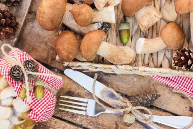 Vejetaryen kümesi: çiğ beyaz mantar, çam kozalakları ahşap masa üzerinde kuru süslemeleri ile