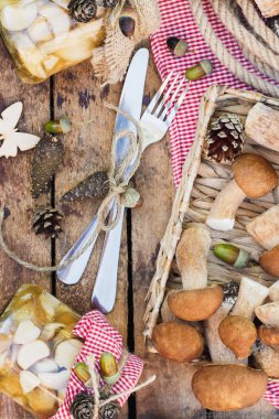 Vejetaryen kümesi: çiğ beyaz mantar, çam kozalakları ahşap masa üzerinde kuru süslemeleri ile