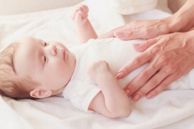 Annenin elleri ve bebeği, içeride, yumuşak odaklı arka plan.