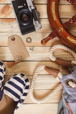Kamera, ayakkabılarla ve deniz dekorasyon ahşap arka planda, üstten görünüm