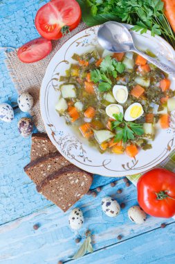 Plaka ile kuzukulağı çorbası, ekmek ve farklı sebze, üstten görünüm
