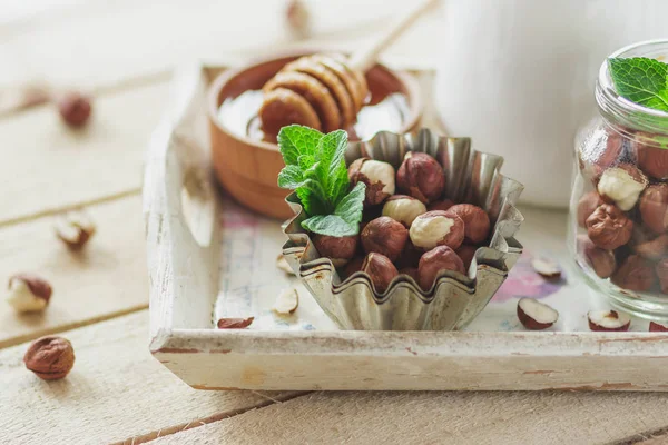 Honung Trä Bowl Mynta Blad Hasselnötter Och Burk Med Mjölk — Stockfoto