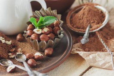 Parça çikolatalı kek, nane yaprağı, fındık ve kavanoz süt, yumuşak odak arka plan ile