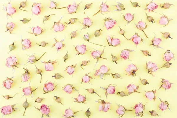 Background made from different rose blossoms on the yellow base, top view