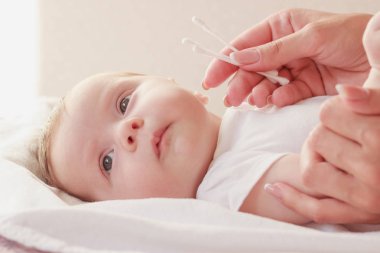 Annenin elleri ve bebeği, içeride, yumuşak odaklı arka plan.