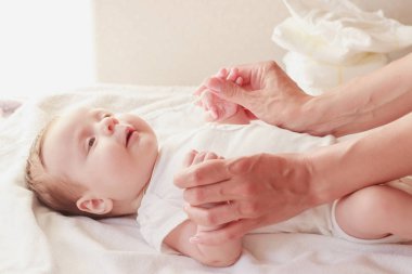 Annenin elleri ve bebeği, içeride, yumuşak odaklı arka plan.