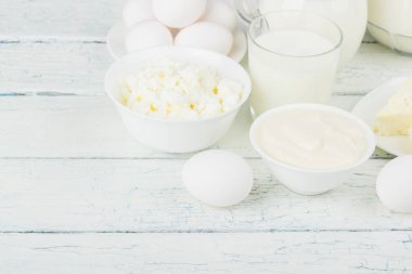 Beyaz tahta tahtalarda farklı süt ürünleri, bulanık arka plan.