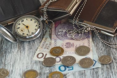 Küçük cüzdan ve eski ahşap arka plan üzerinde cep saati ile Polonya Zlotisi