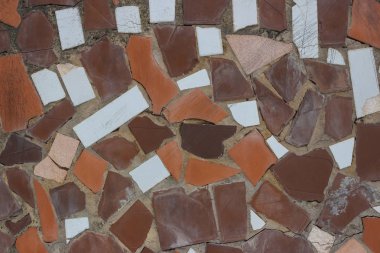 Beyaz ve kahverengi kayalardan yapılmış gri bir yüzey. Farklı kusurları ve eski dokuları var.