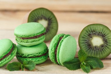 Yeşil kivi ve nane süslemeleri, yumuşak odak arka plan ile Fransız macarons