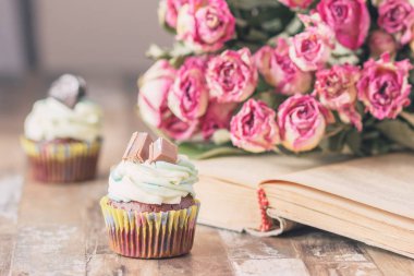 El yapımı çikolata muffins süslemeleri ile. Kitap ve bir buket gül, arka plan bulanık