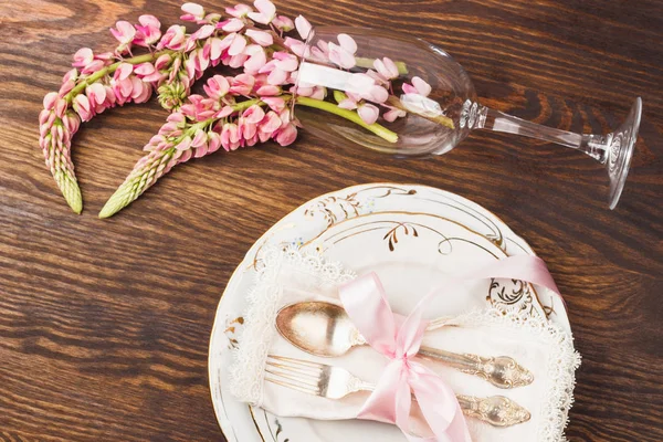 Посуд з рожевими люпинами та срібним посудом — стокове фото