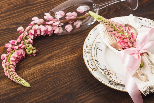 Посуд з рожевими люпинами та срібним посудом — стокове фото