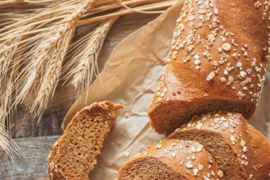 Kepekli, buğday kulağı ve ahşap arka plan ile el yapımı ekmek