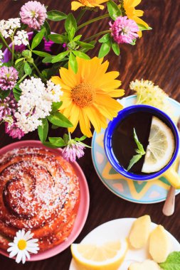 Ahşap arka planda gevrek kabuk ile limon ve nane ve farklı pişmiş ürünler ile yeşil çay