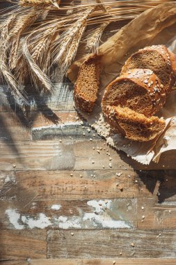 Kepekli, buğday kulağı ve ahşap arka plan ile el yapımı ekmek