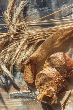 Kepekli, buğday kulağı ve ahşap arka plan ile el yapımı ekmek