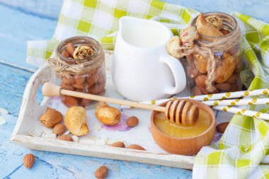 Ahşap tepside süt ile badem, bal ve kavanoz