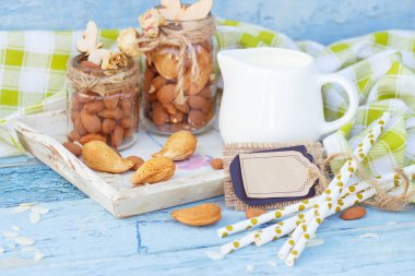 Badem ve kavanoz ahşap tepsi sütlü ahşap arka plan