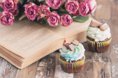 Dekorasyon ile el yapımı çikolatalı kekler. Kitap ve bir buket gül