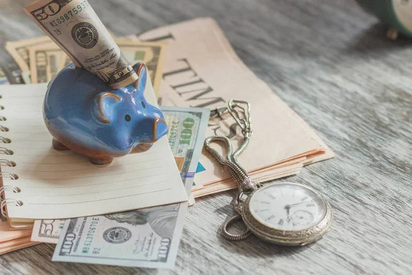 Piggy bank with American dollars and a pocket watch — Stock Photo, Image