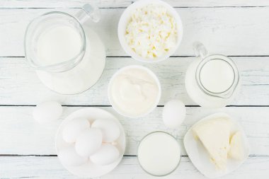 Beyaz ahşap tahtalarda farklı süt ürünleri